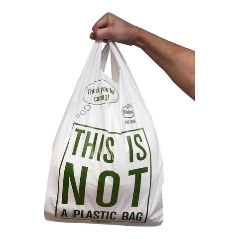 A compostable carry bag being held.