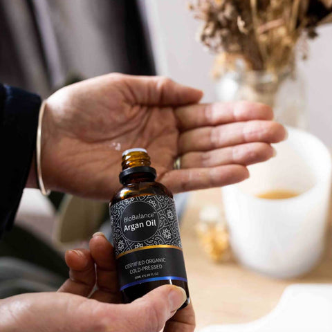 Person pouring BioBalance Certified Organic Argan Oil into their hand, high in vitamin E and is very moisturising, quickly absorbed, a natural antioxidant and anti-inflammatory.