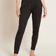 A model wearing black, lightweight lounge pants made of organic bamboo, featuring a draped fit with a wide waistband, tapered leg and two side pockets, showing the front.