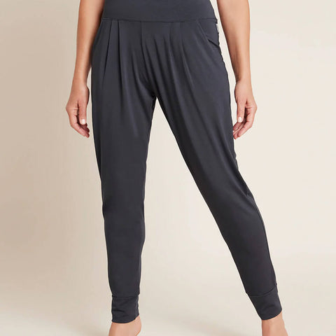 A model wearing navy blue, lightweight lounge pants made of organic bamboo, featuring a draped fit with a wide waistband, tapered leg and two side pockets, showing the front.