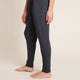 A model wearing navy blue, lightweight lounge pants made of organic bamboo, featuring a draped fit with a wide waistband, tapered leg and two side pockets, showing the side.