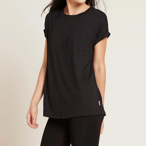 A model wearing a black, lightweight lounge top made of organic bamboo, featuring a softly curved neckline, back seam detail and a subtle curved high-to-low-hem, showing the front.