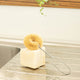 Plastic free, coconut fibre dish brush placed on a block of soap on a kitchen counter.