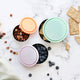 3 round stainless steel containers with pastel coloured lids styled on a marble counter with snacks.