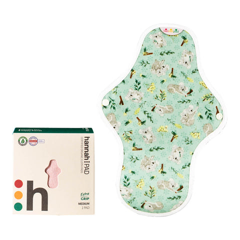 Box of hannahPAD reusable medium pad made from certified organic cotton, featuring double snap fasteners and silicone grips to prevent slippage, next to a medium pad with a koala pattern.