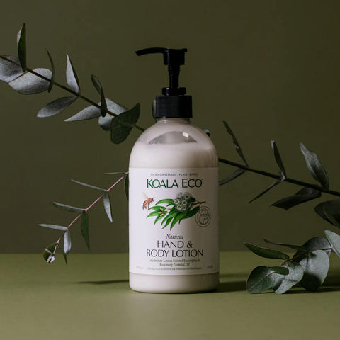 Plastic pump bottle of lemon scented eucalyptus and rosemary natural hand and body lotion styled with plants on a surface.