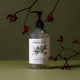 Plastic pump bottle of rosalina and peppermint natural hand wash styled with plants on a surface.