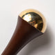 Rounded end of ayurvedic kansa wand made with teak wood and bronze.