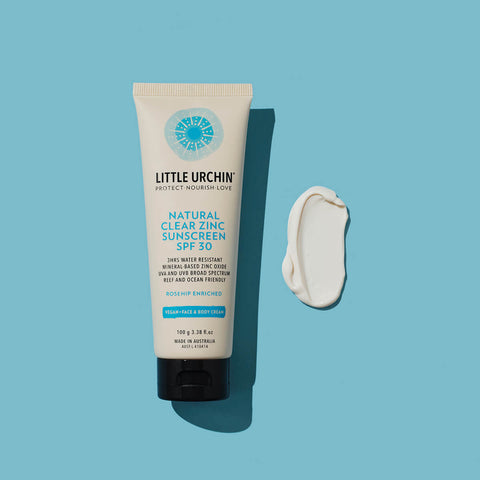 Swatch of Natural Zinc Stick SPF 30, a clear, hydrating, vegan formula that provides UVA and UVB broad-spectrum protection from the sun while also being 4 hours water-resistant, next to its 20g tube. Packaged in a cream tube with minimal blue and black text on the label.