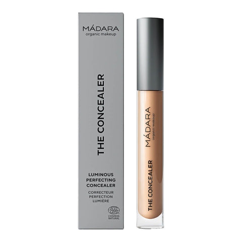 Madara The Concealer in shade Golden Hour #40, a naturally certified concealer that hides dark circles, blemishes, and redness with a dewy finish. It offers long-lasting comfort and contains hydrating hyaluronic acid and retouching minerals. Packaged in a slim, cylindrical tube with a twist-off cap and a built-in applicator, featuring the brand name on the label.