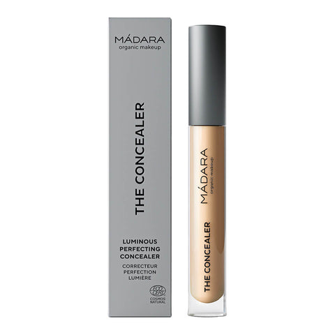 Madara The Concealer in shade Honey #35, a naturally certified concealer that hides dark circles, blemishes, and redness with a dewy finish. It offers long-lasting comfort and contains hydrating hyaluronic acid and retouching minerals. Packaged in a slim, cylindrical tube with a twist-off cap and a built-in applicator, featuring the brand name on the label.