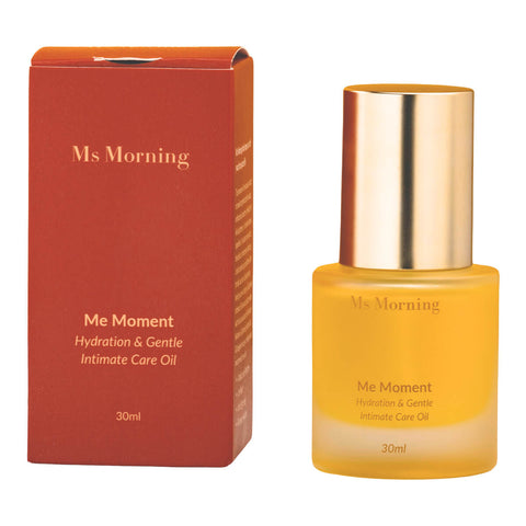 30ml bottle of Ms Morning Me Moment Hydration & Gentle Intimate Care Oil, a premium oil meticulously crafted to provide targeted benefits, including antibacterial protection, itch relief, and skin brightening, next to its red box. Packaged in a frosted glass bottle with a gold cap.