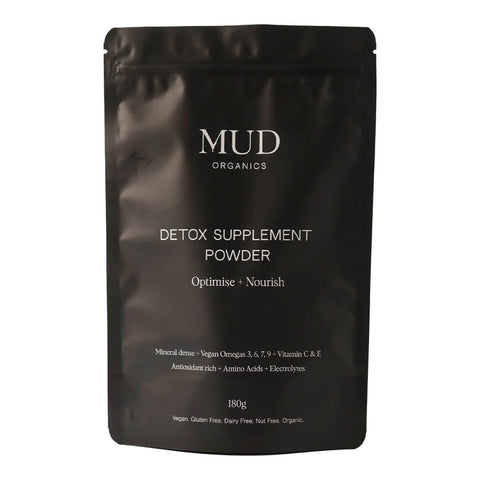 180g resealable bag of Mud Organics Detox Supplement Powder, featuring a blend of fulvic acid and Omegia™ powder (sea buckthorn) to support natural detoxification. Promotes renewed energy, improved mental clarity, collagen formation, and a healthier immune system. Packaged in a black plastic bag.