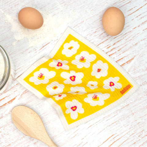 Compostable sponge cloth with a retro flower design on a bench.