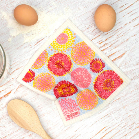 Compostable sponge cloth with a waratah design on a bench.