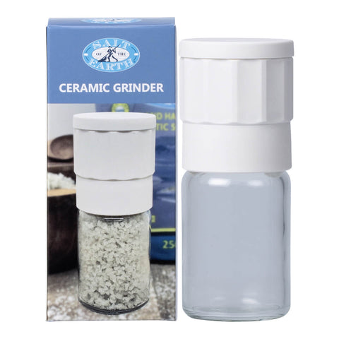 Salt of the Earth Ceramic Sea Salt Grinder next to its box, a spice grinder out of a fine porcelain material that is non-corrosive. Metal and nylon free grinding mechanism. Easy to clean with a removable and refillable glass jar.