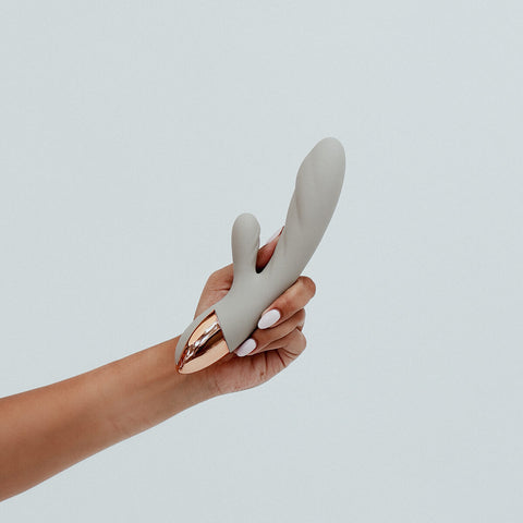 Hand holding Viola Green Essence Rabbit Vibrator in Pistachio nude colour, a dual-action rabbit vibrator. With whisper-quiet motors and customisable settings, allowing you to tailor all your intimate experiences. Its ribbed shaft adds delightful textures, taking your pleasure to elevated heights. Crafted from sustainable materials, Essence is an eco-friendly choice that combines sophistication with responsible pleasure, ensuring every intimate moment is both satisfying and guilt-free.