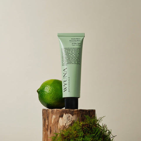 Tube of vegan cleansing balm styled with a lime and botanicals.